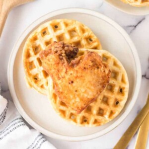 crispy chicken atop homemade waffles and maple syrup