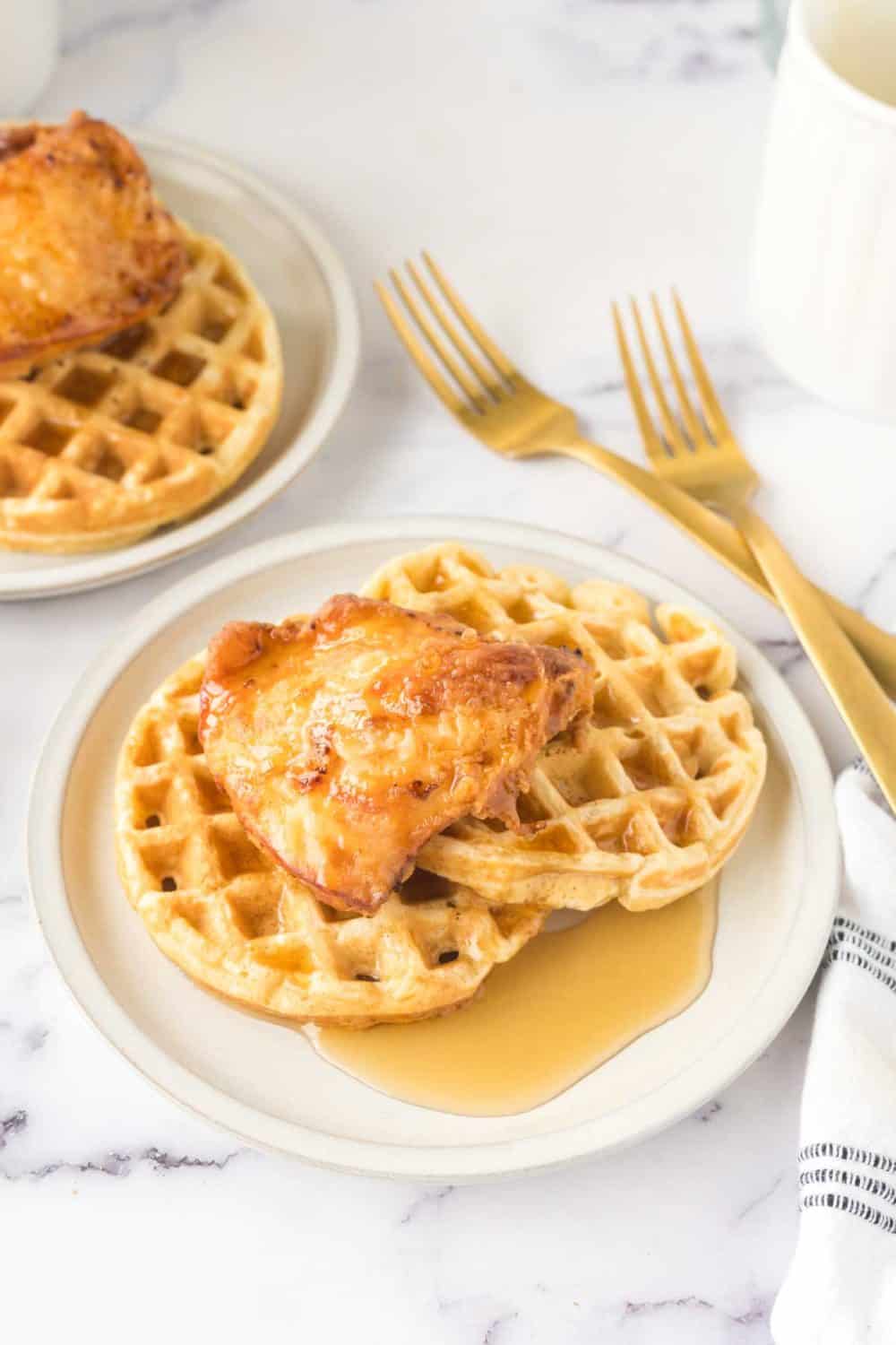 crispy chicken atop homemade waffles and maple syrup