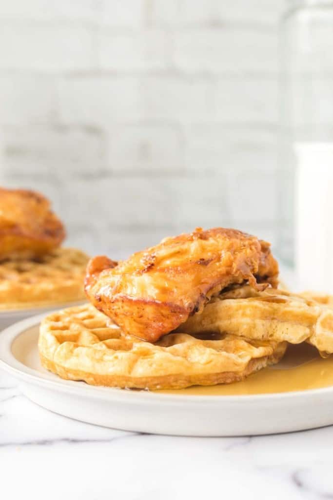 crispy chicken atop homemade waffles and maple syrup