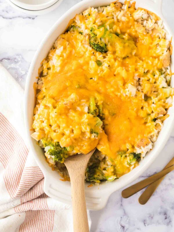 top view of wooden spoon scooping chicken broccoli rice casserole from the baking dish