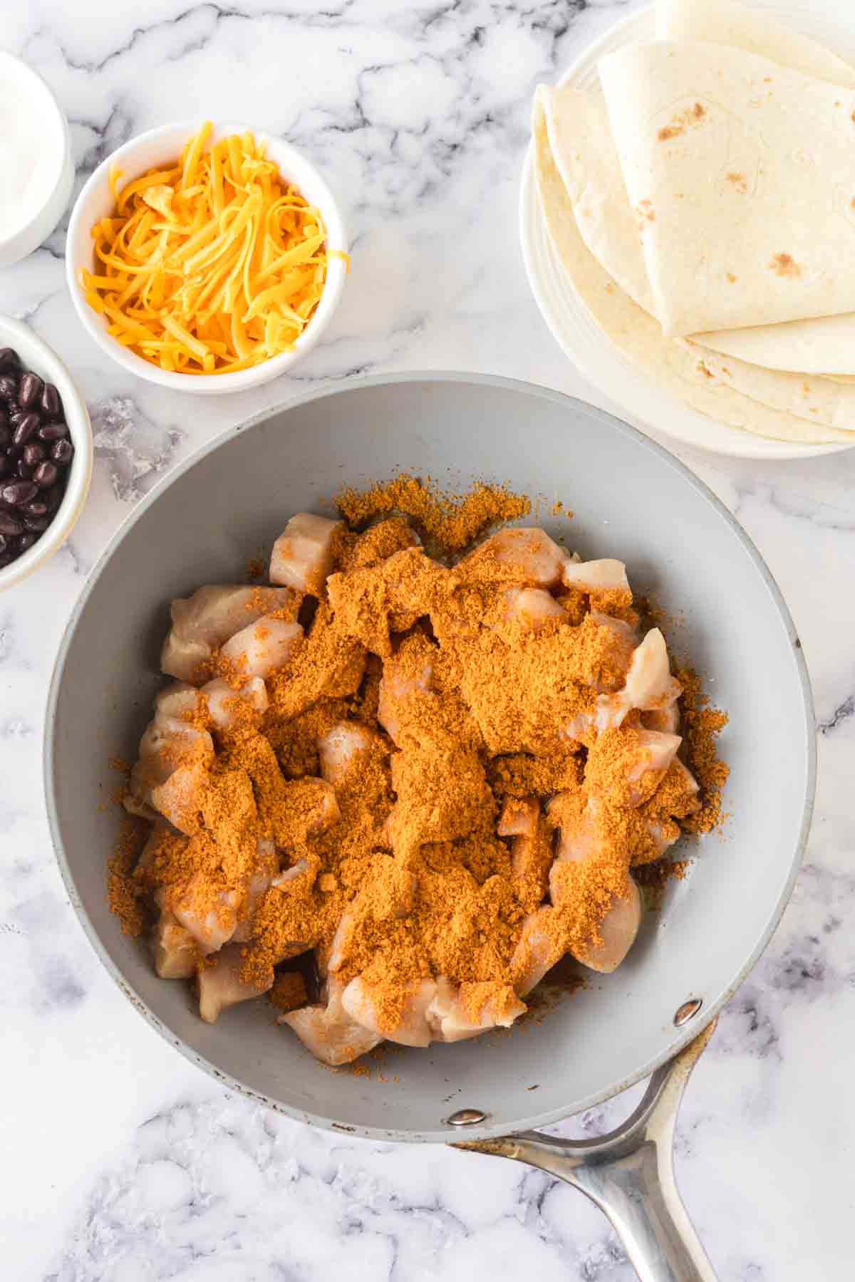raw chicken and ingredients for chicken burritos