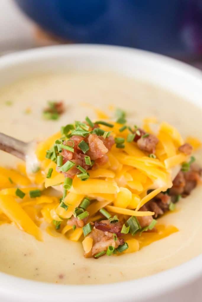 close up of cream of potato soup with cheese and bacon on top