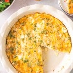 top view of a whole crustless quiche in the baking dish with one slice taken out