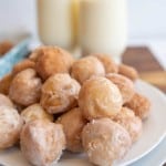 plate stacked with round iced and sugar donut hole bites