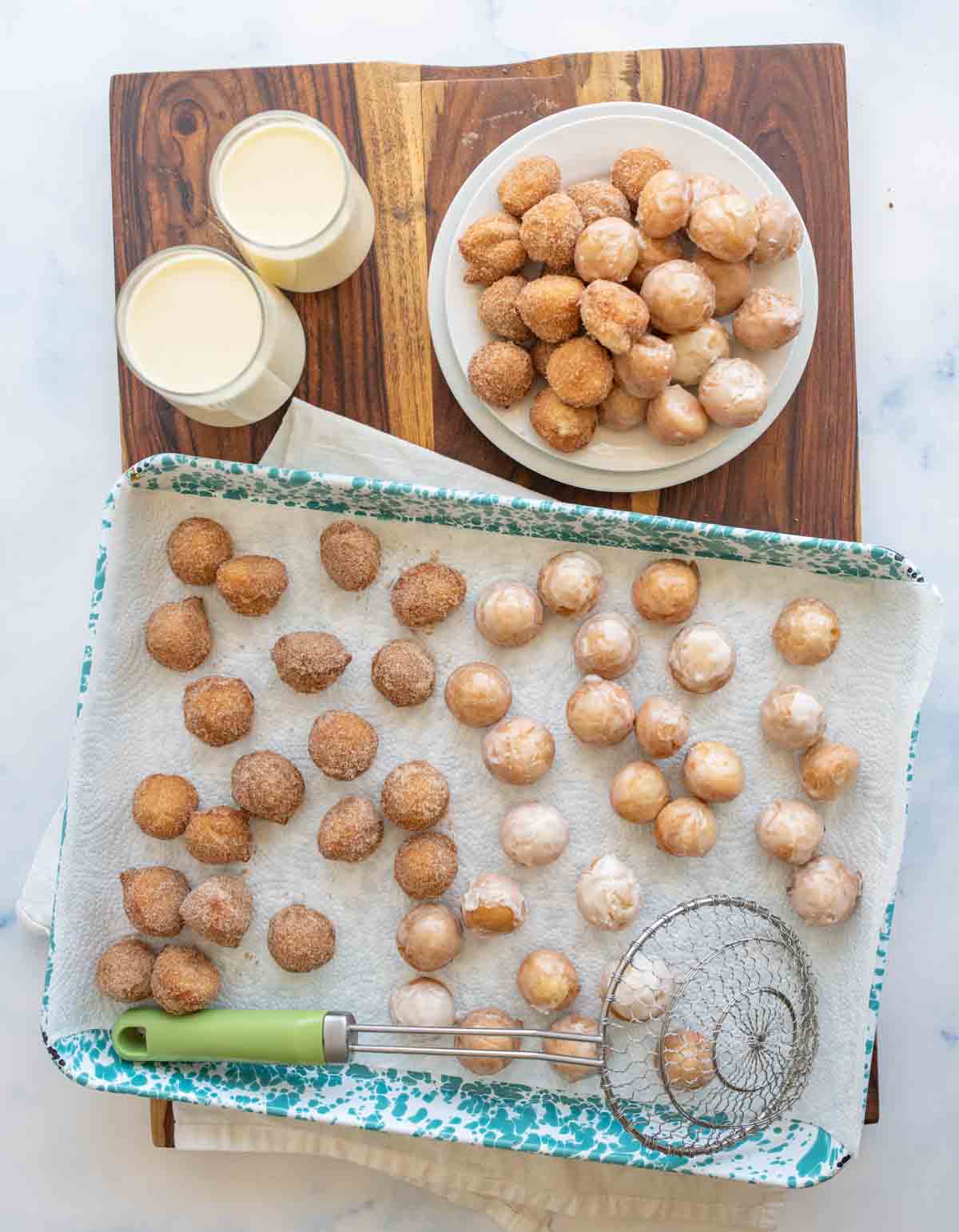 round iced and sugar donut hole bites on a baking dish