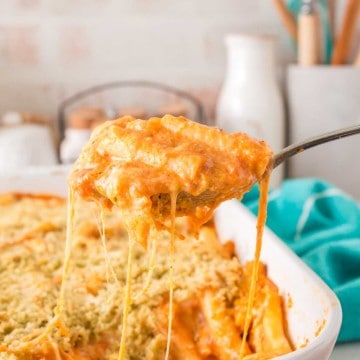 five cheese zita forno pasta with a creamy red sauce in a white baking dish being spooned out