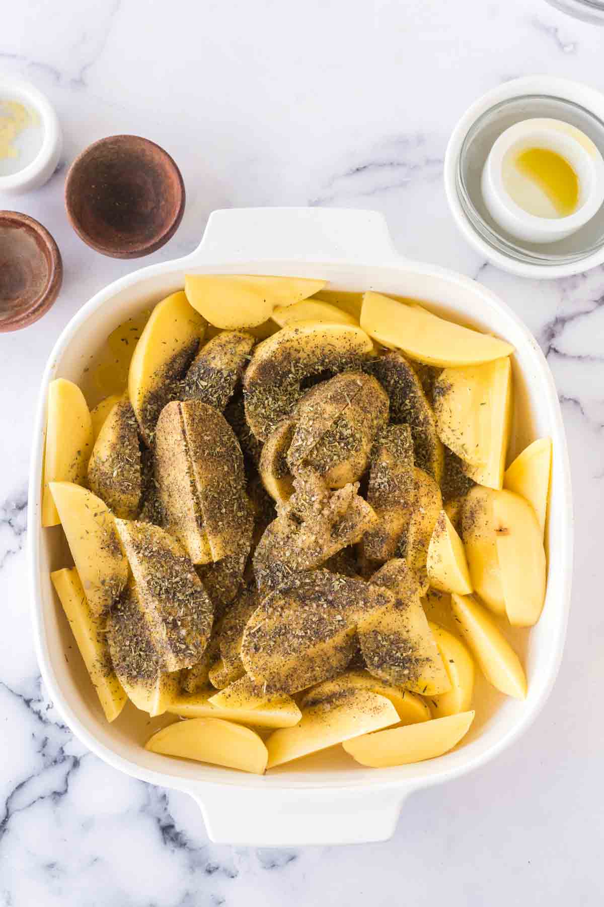 raw greek potato ingredients in a baking dish