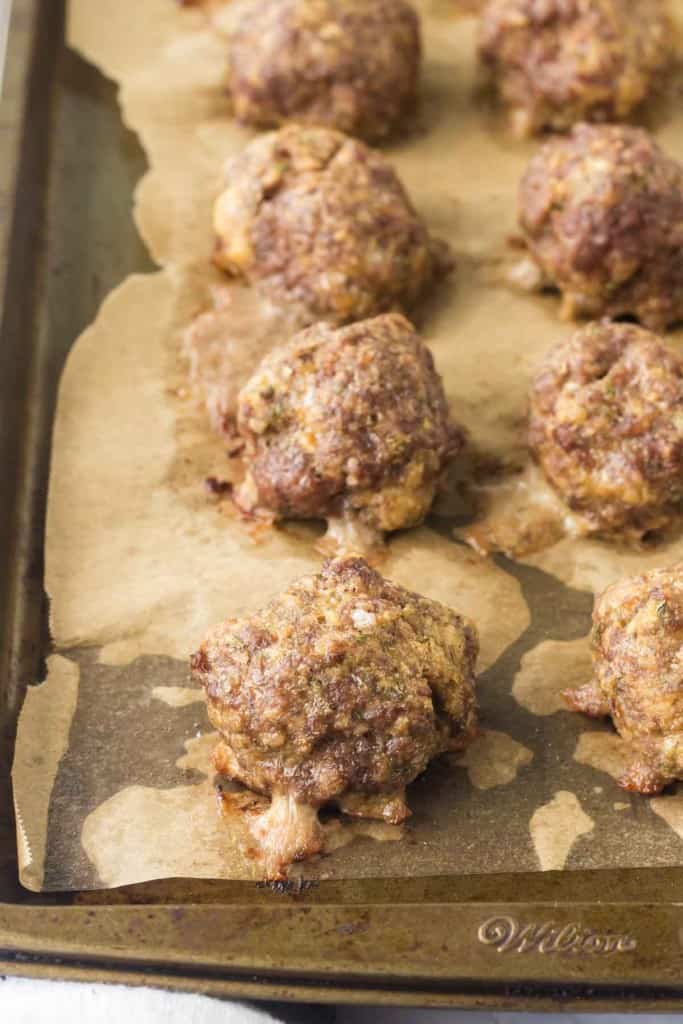 baked Italian meatballs on a parchment lined tray