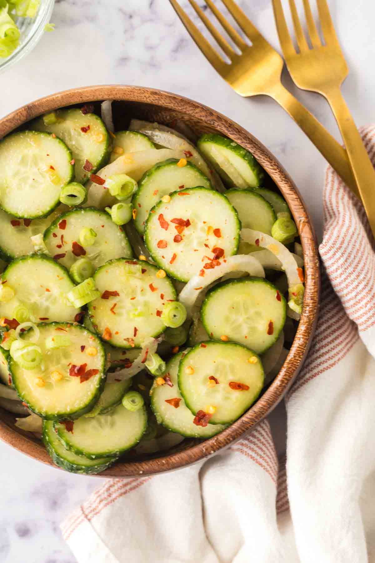 slices of cucumber and spices in a bowl for korean cucumber salad