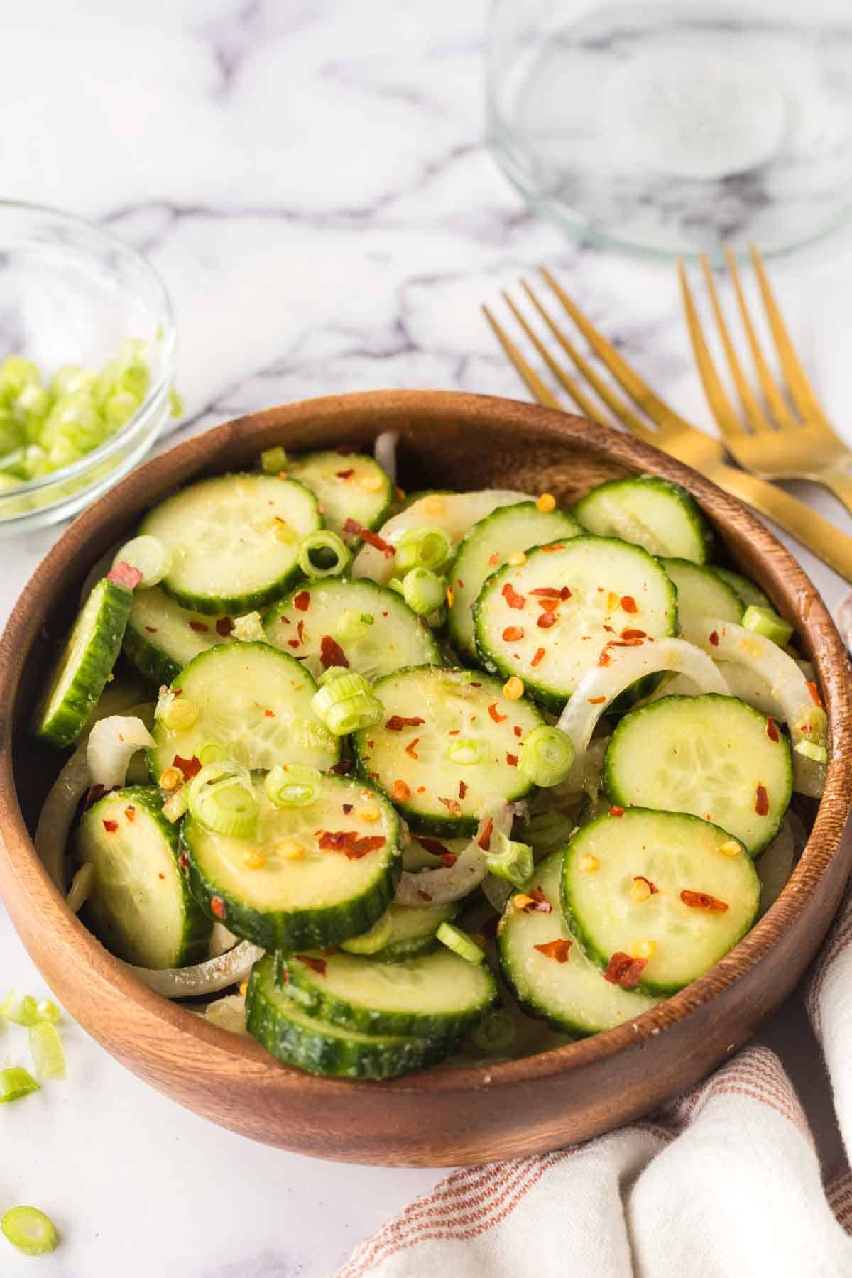 slices of cucumber and spices in a bowl for korean cucumber salad