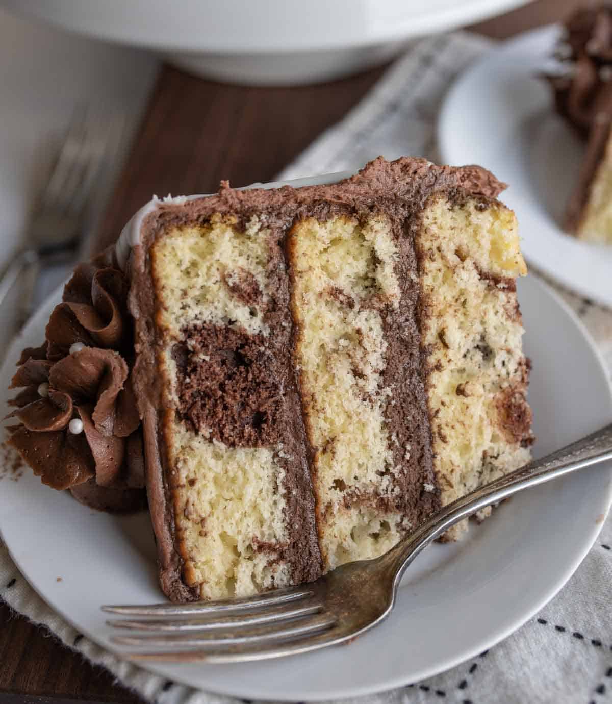 slice of three layered marble cake mixed with vanilla and chocolate cake