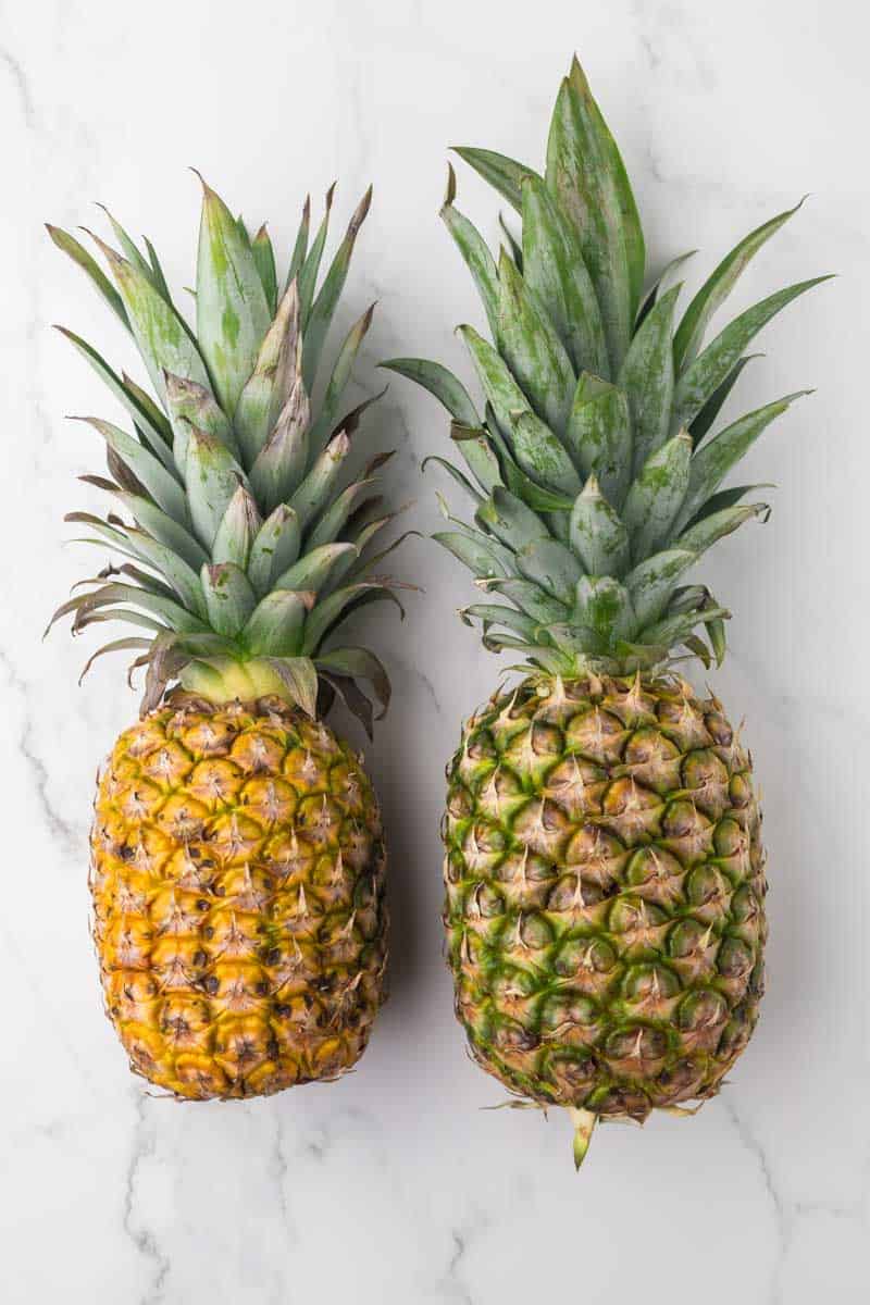 two whole pineapples on a table