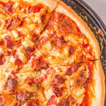 homemade baked pineapple pizza on a cast iron pan