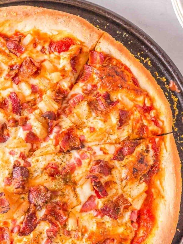 homemade baked pineapple pizza on a cast iron pan