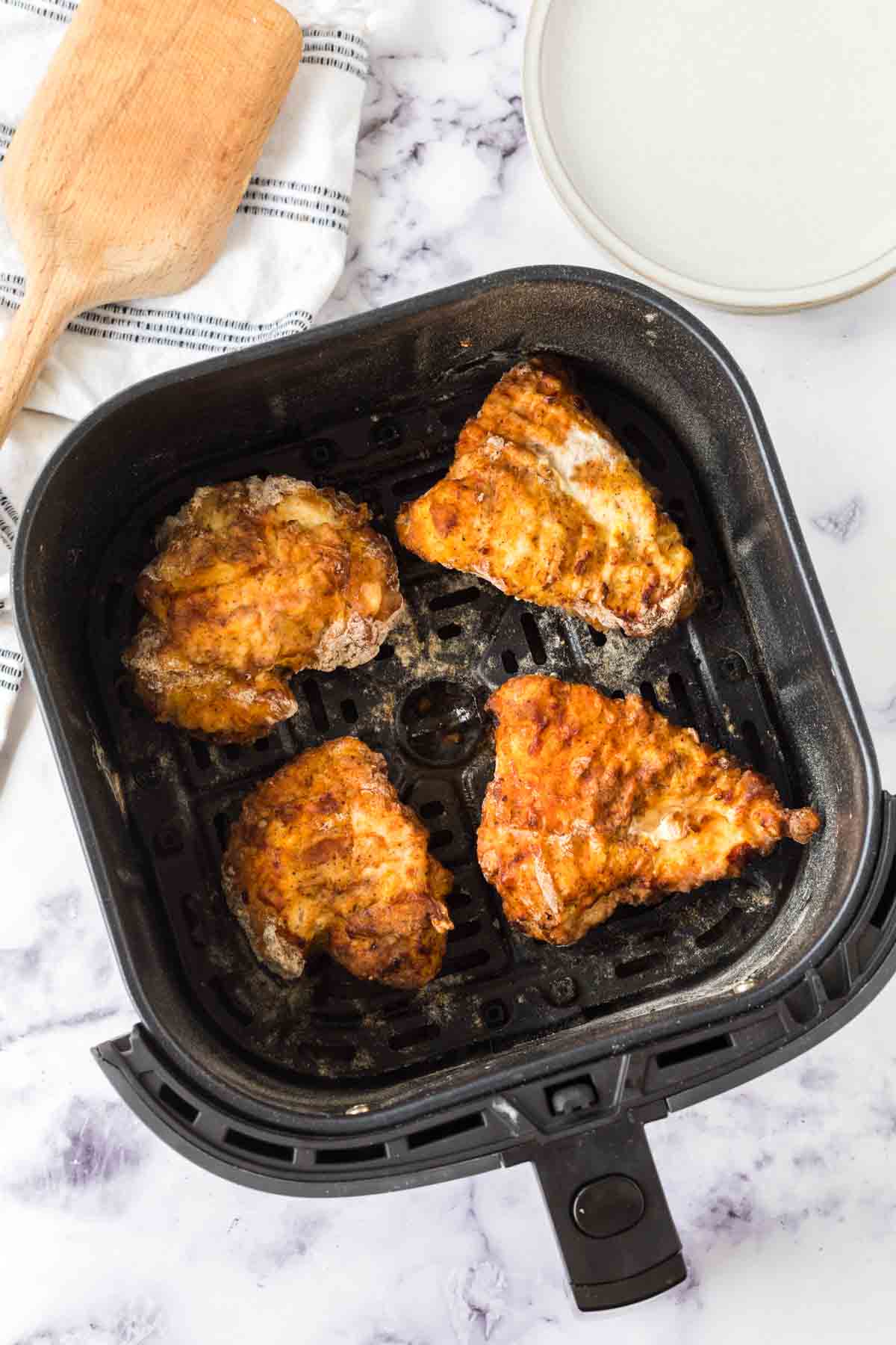 air fryer basket of fried chicken