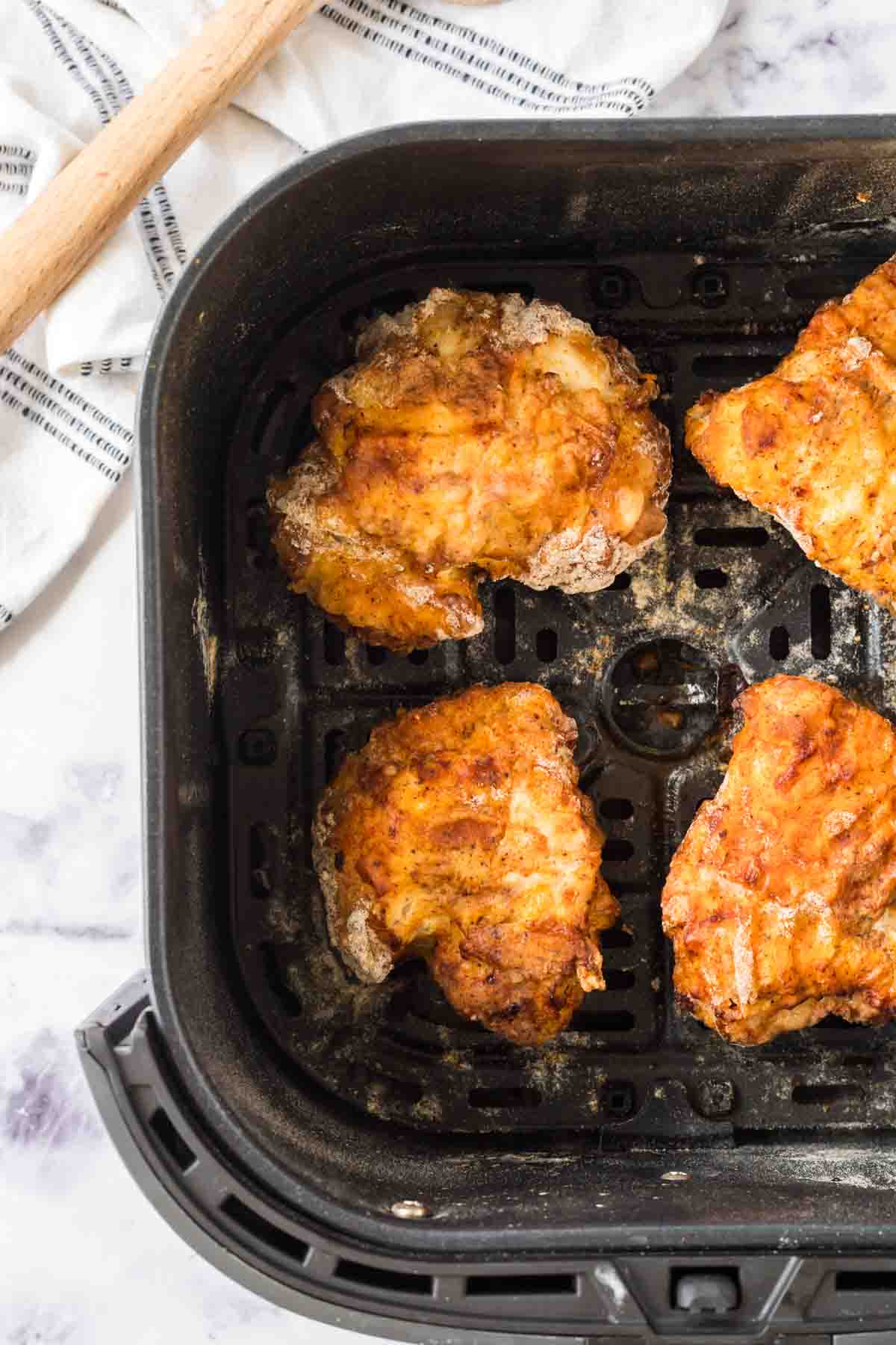 air fryer basket of fried chicken