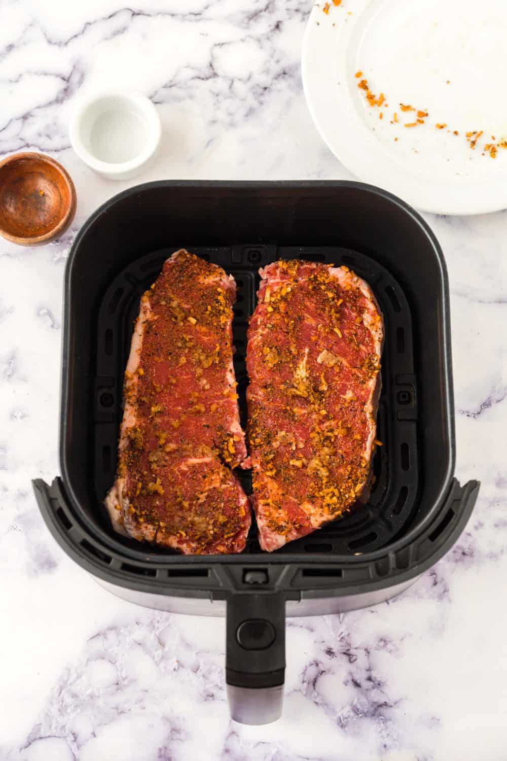 raw seasoned steak in the air fryer
