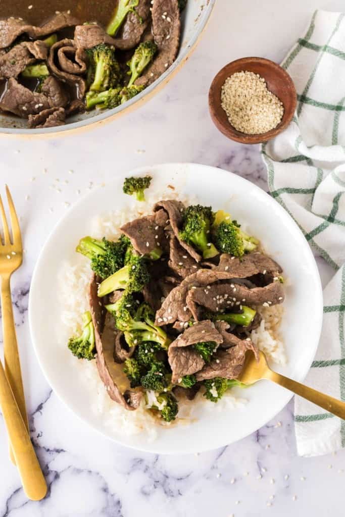 Beef and broccoli served in a white bowl and ready to eat.