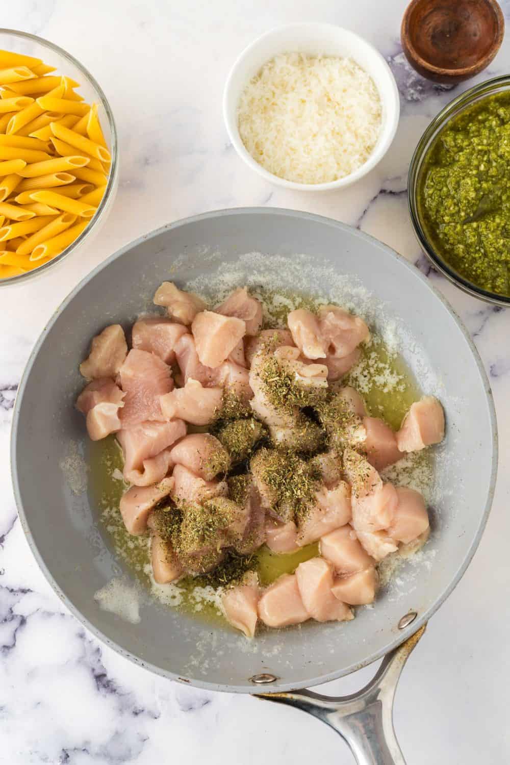 Chicken in a pan ready to make chicken pesto pasta.