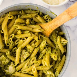 spoonful of chicken pesto pasta over a pot