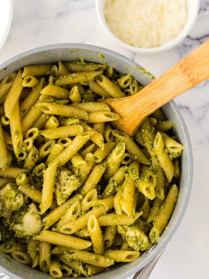 spoonful of chicken pesto pasta over a pot