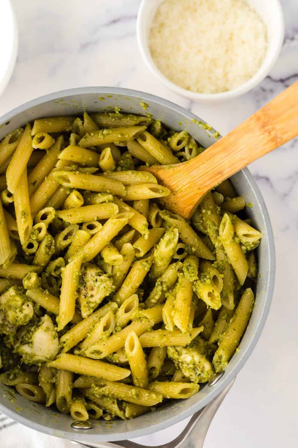 spoonful of chicken pesto pasta over a pot