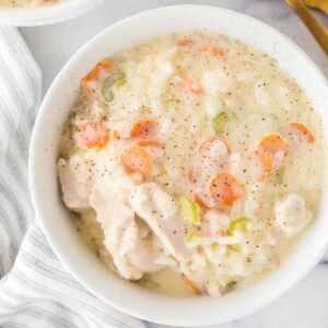 chicken and rice soup in a white serving bowl