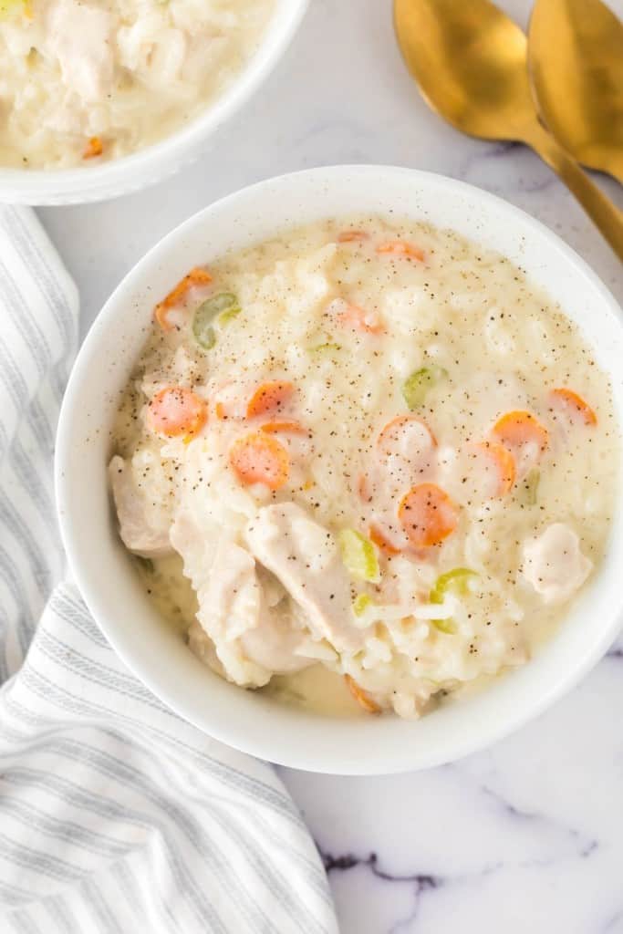 chicken and rice soup in a white serving bowl