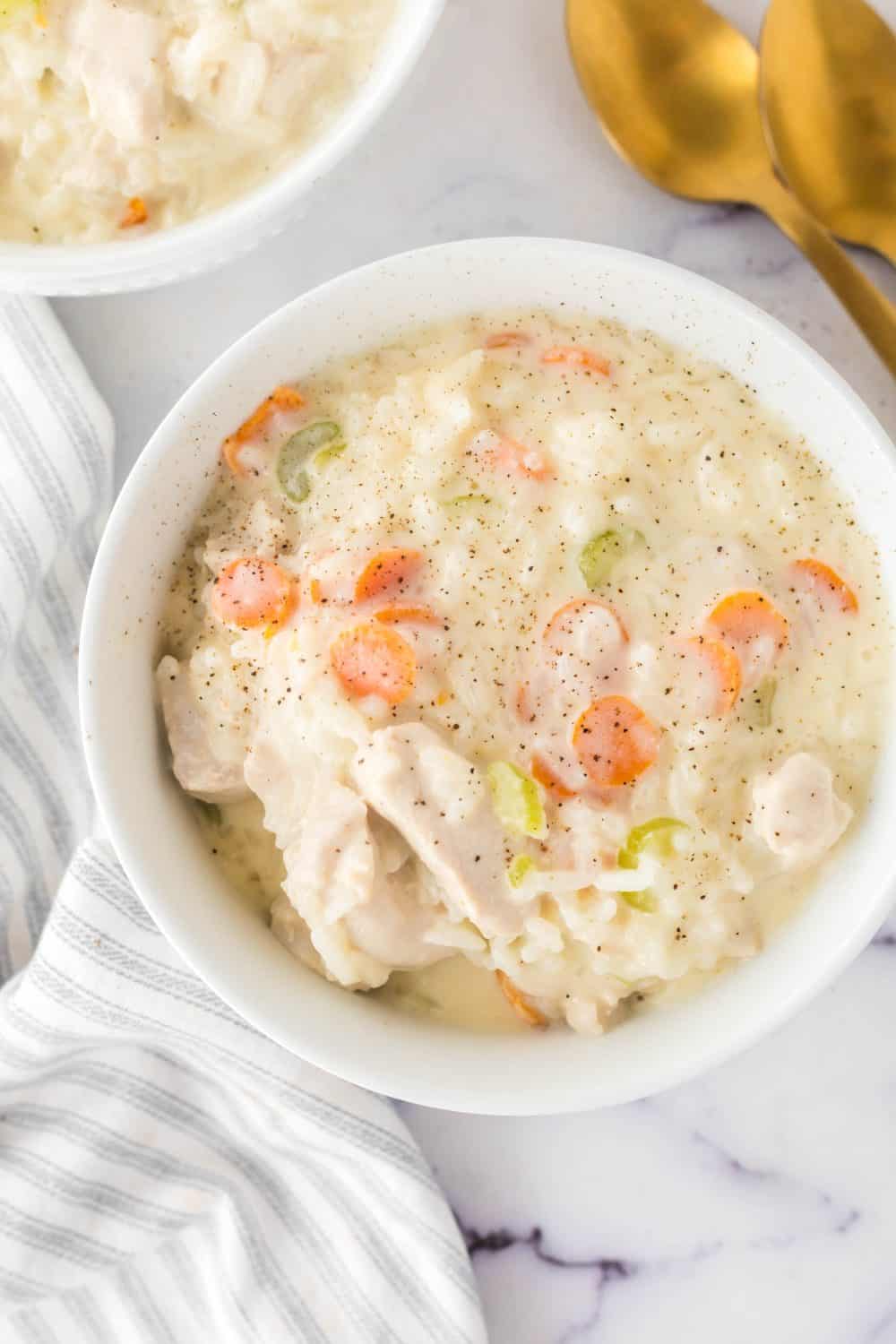 chicken and rice soup in a white serving bowl