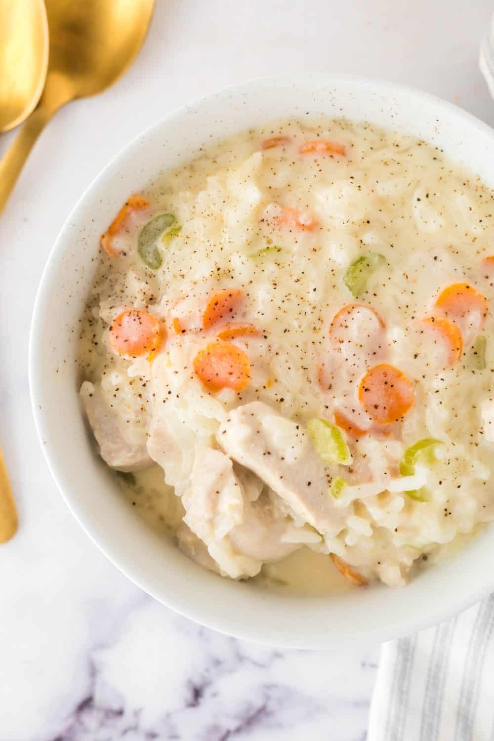 chicken and rice soup in a white serving bowl