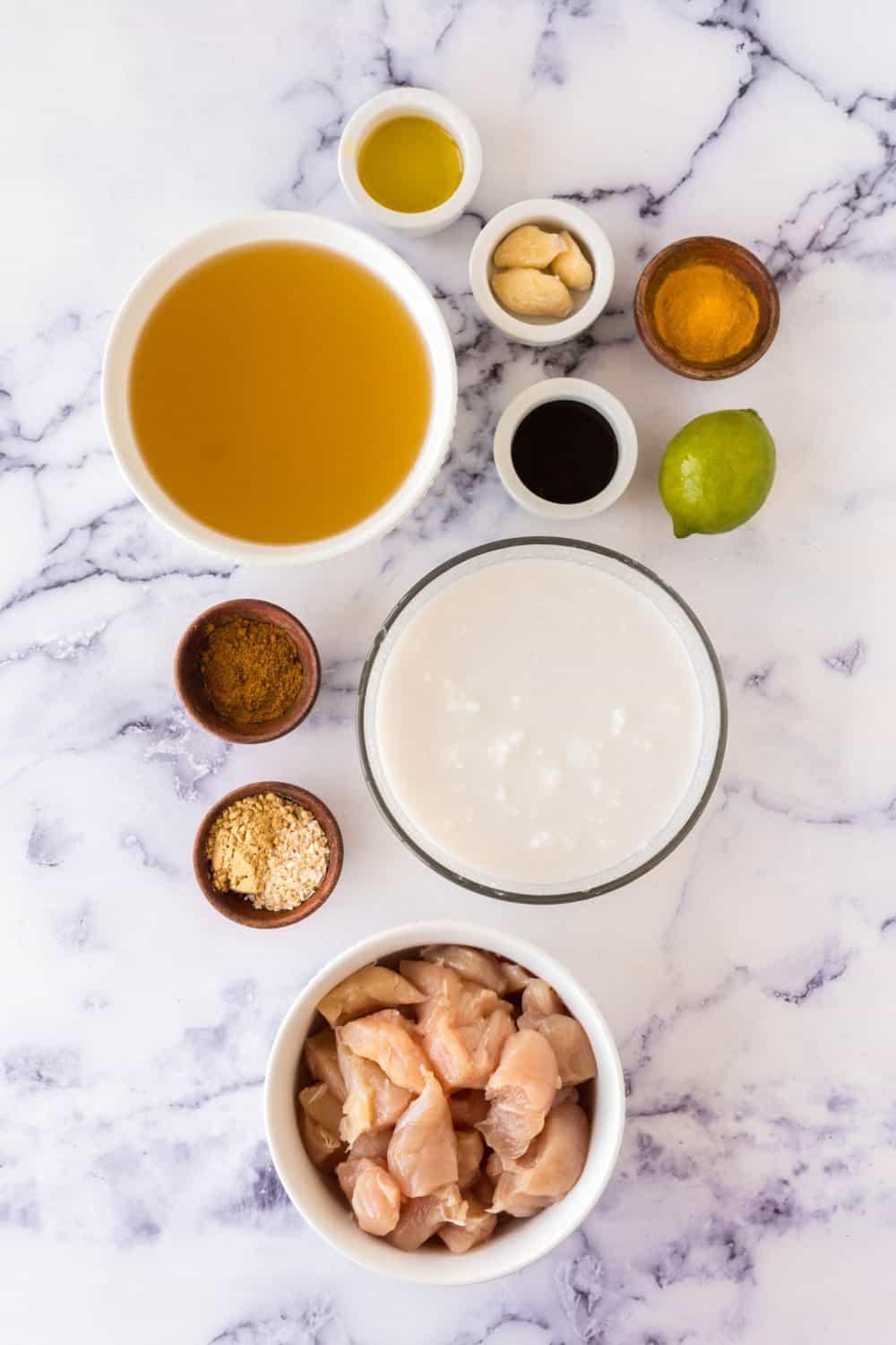 raw ingredients for chicken curry portioned out in small bowls