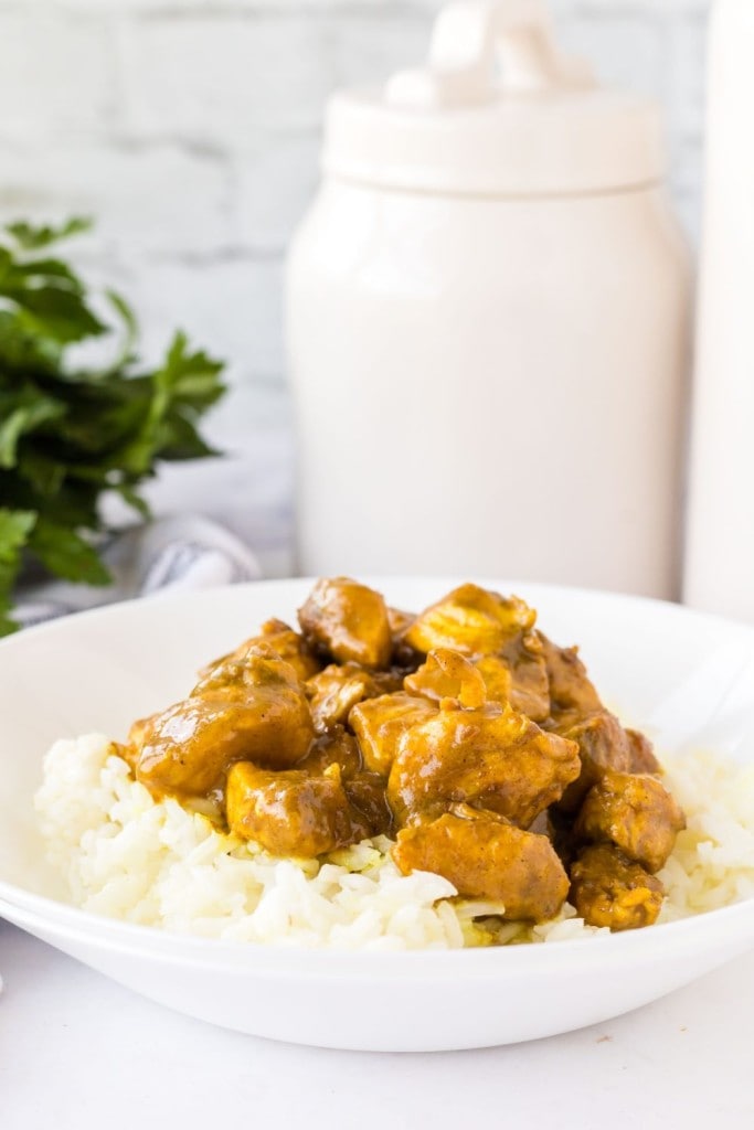 tapered white bowl with coconut chicken curry over white rice