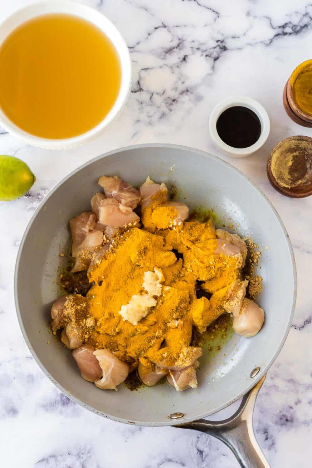 raw ingredients for chicken curry in a pan