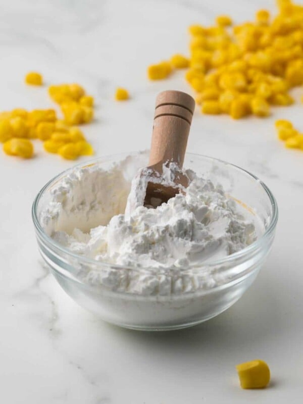 Cornstarch in a bowl with water to make a slurry and corn kernels all around