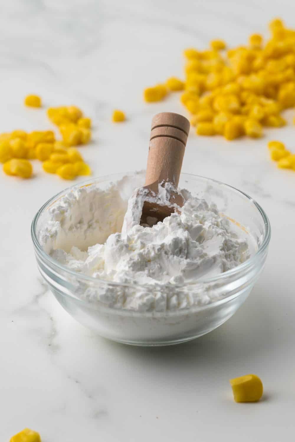 Cornstarch in a bowl with water to make a slurry and corn kernels all around