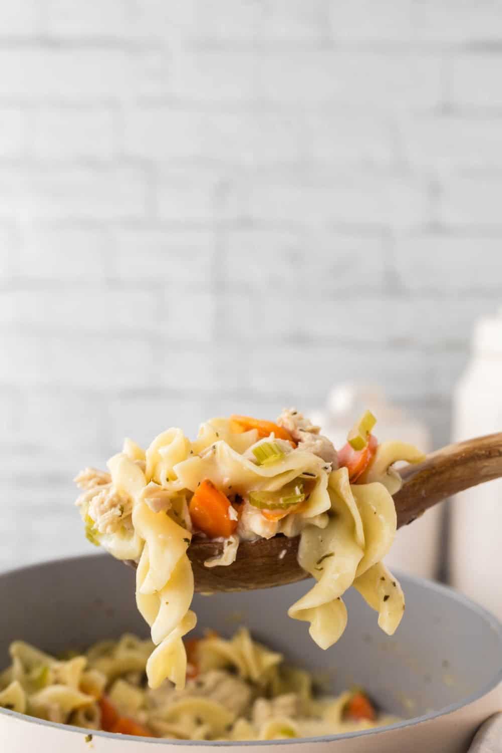 wooden spoon full of creamy chicken noodle soup
