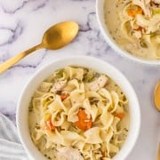 top view of a white bowl of creamy chicken noodle soup