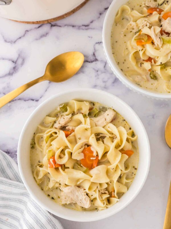 top view of a white bowl of creamy chicken noodle soup