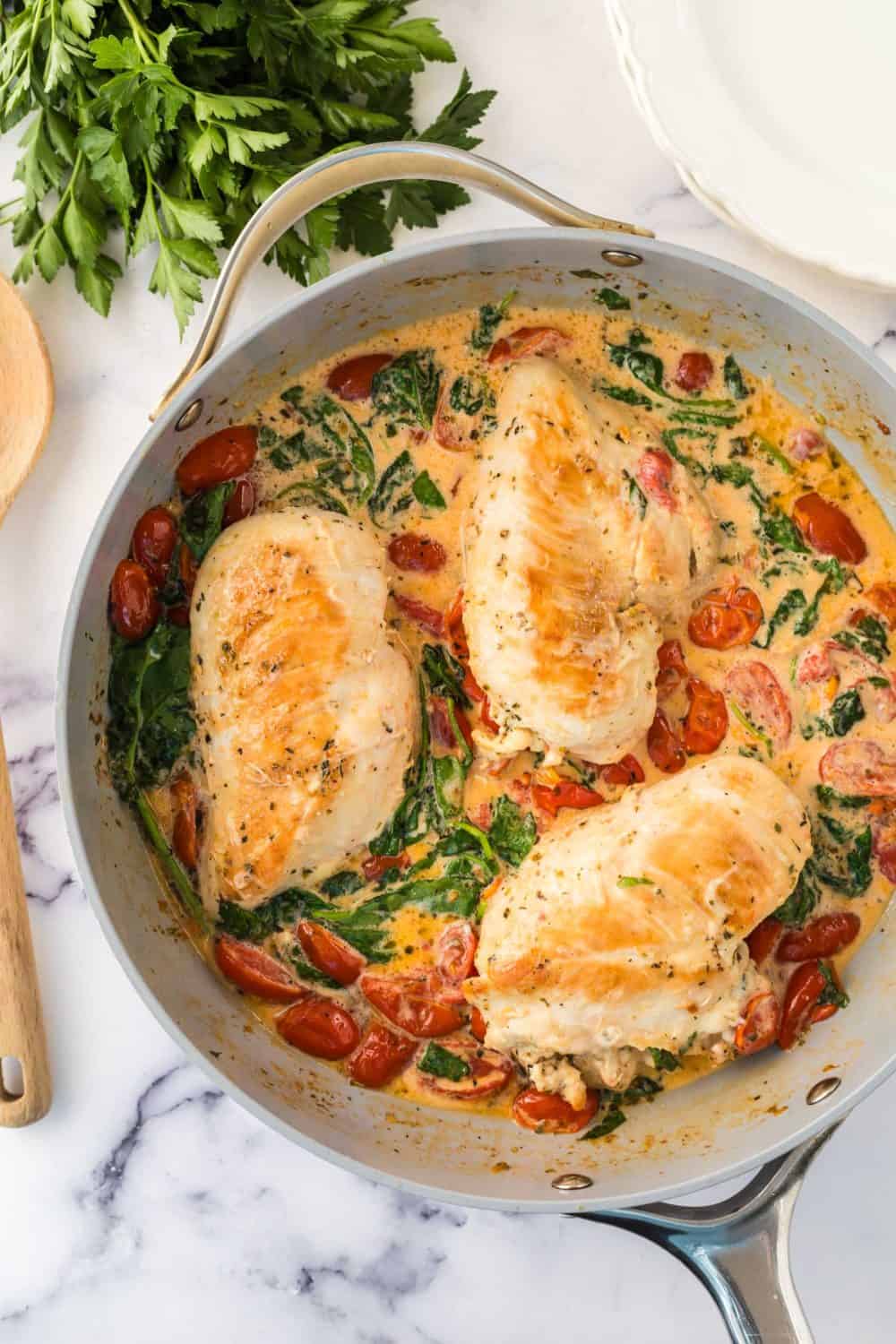 Creamy tuscan chicken baking in pot.