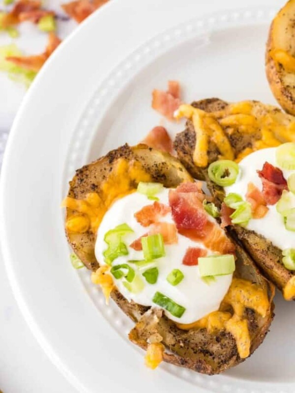 round plate with baked potato skins with melted cheese sour cream and toppings