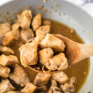 honey chicken on a wooden spoon