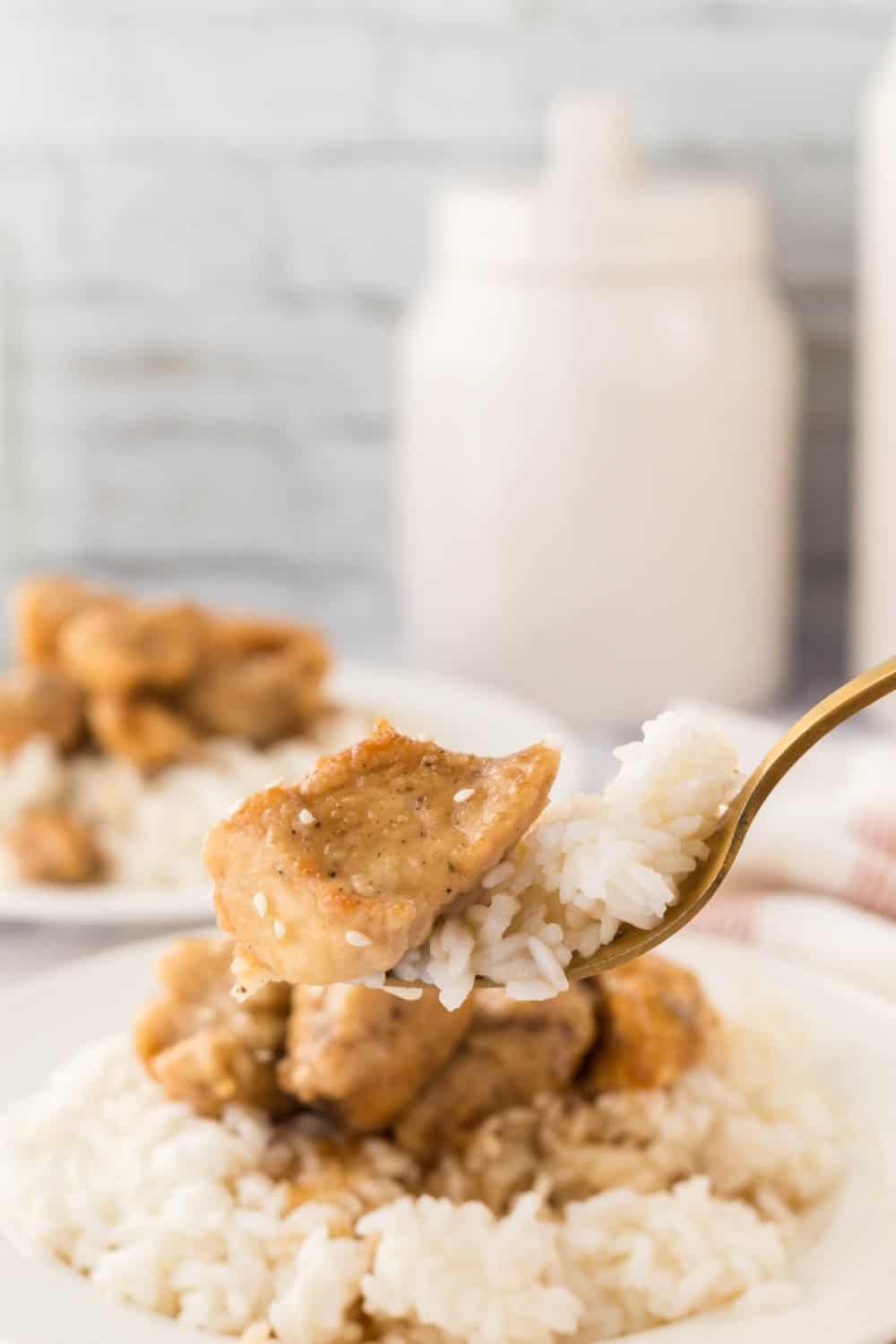 honey chicken cubes and rice on a fork