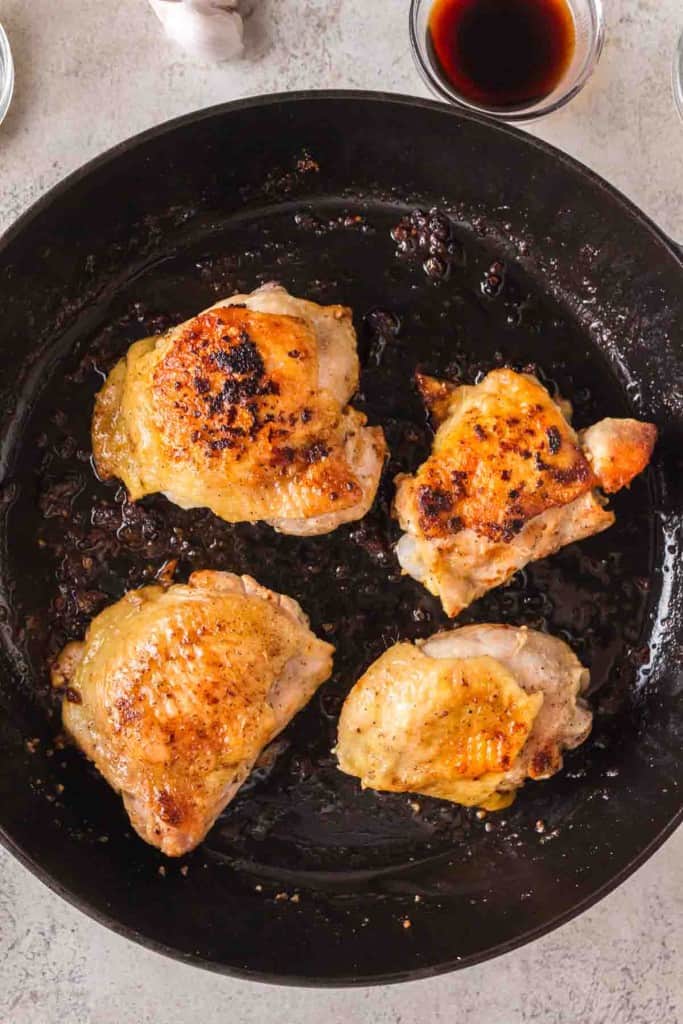 seared chicken thigh in a cast iron pan