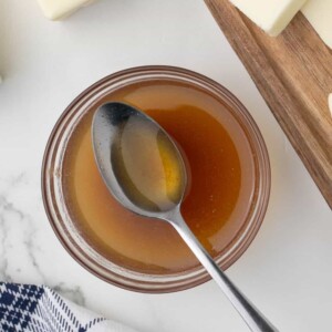 a clear glass bowl of melted brown butter and a spoon in an aesthetic photo