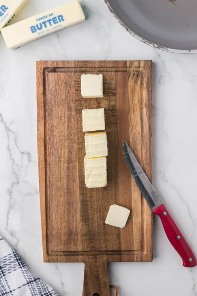 Cutting butter into cubes to brown butter. 
