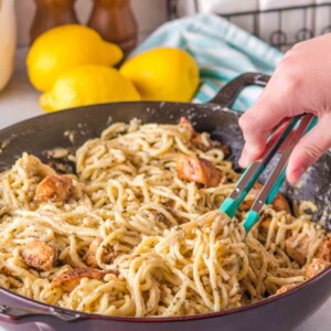 lemon chicken pasta being stirred by tongs