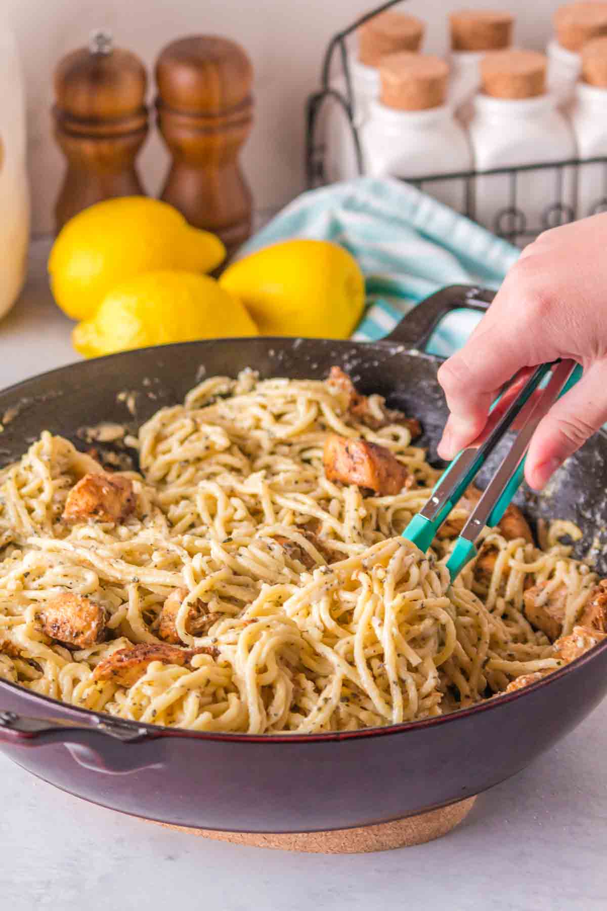lemon chicken pasta being stirred by tongs