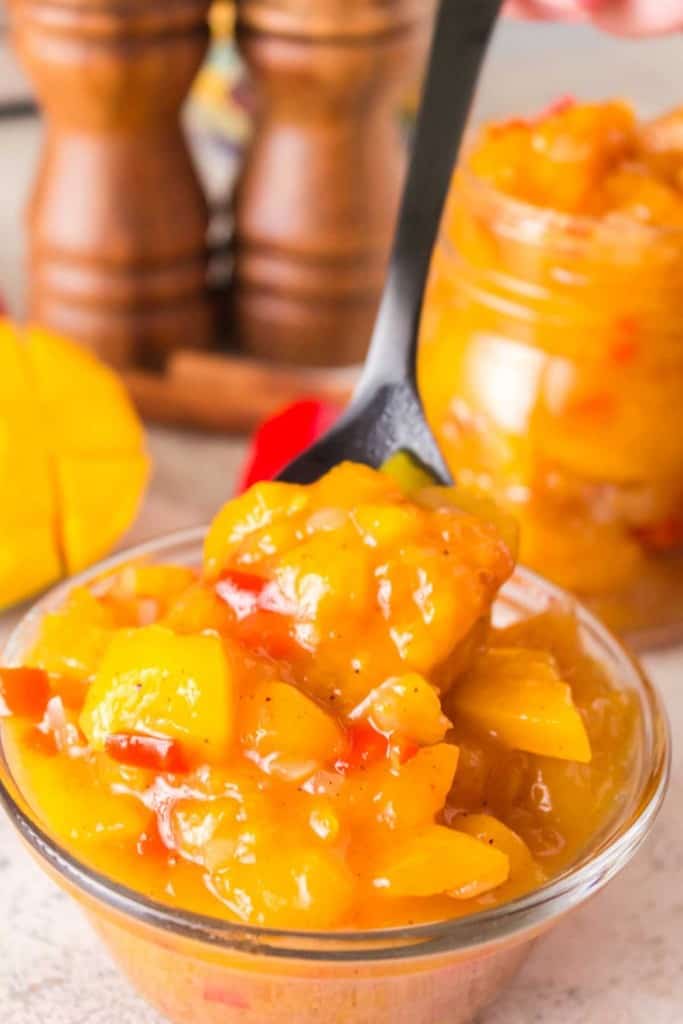 mango chutney in a small glass bowl and a spoon
