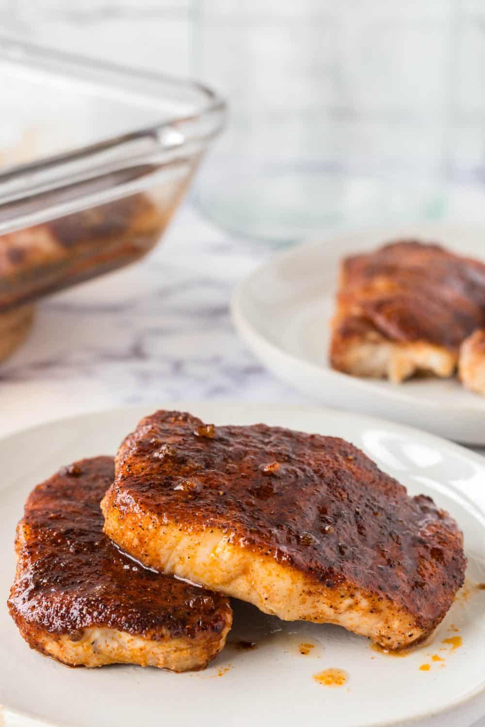 round white plate with seasoned and baked pork chops stacked