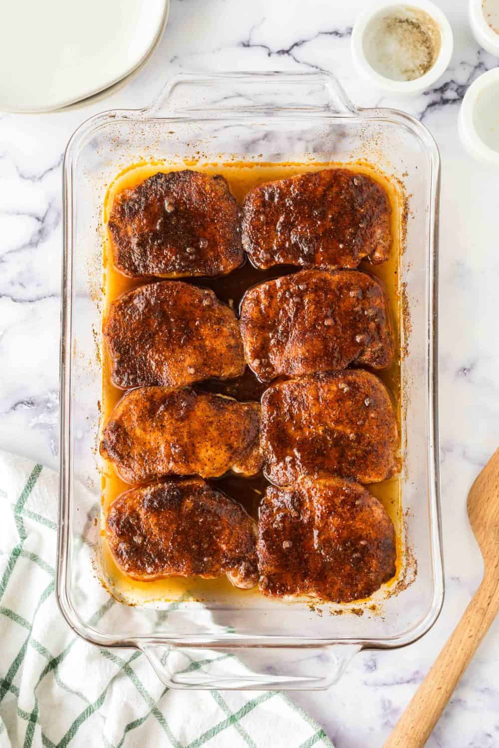 clear baking dish with seasoned pork chops